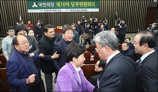 12일 오후 국회에서 바른정당과의 통합을 위한 전당대회 개최 논의를 위해 열린 국민의당 당무위원회에서 통합에 반대하는 유성엽, 장병완 의원이 안철수 대표에게 항의하자 통합 찬성파 당무위원들이 삿대질을 하며 "금뱃지면 다냐?"고 따지며 달려들고 있다. ⓒ데일리안 박항구 기자