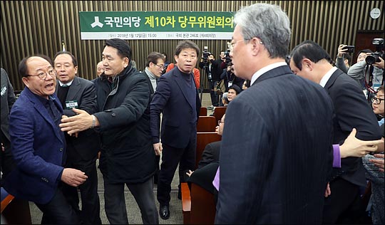 12일 오후 국회에서 바른정당과의 통합을 위한 전당대회 개최 논의를 위해 열린 국민의당 당무위원회에서 통합에 반대하는 유성엽, 장병완 의원이 안철수 대표에게 항의하자 통합 찬성파 당무위원들이 삿대질과 "금뱃지면 다냐?"고 따지며 달려들고 있다. ⓒ데일리안 박항구 기자