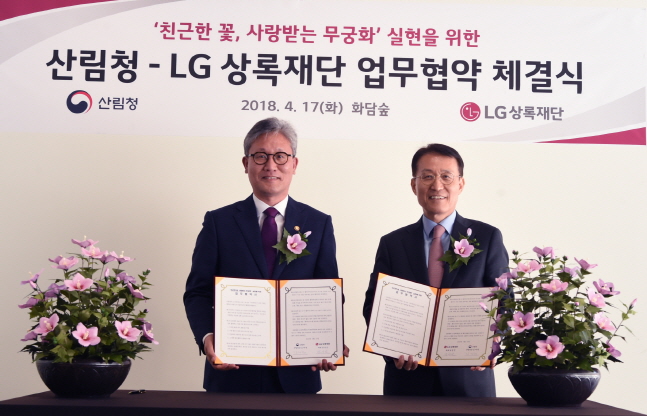 남상건 LG상록재단 대표(오른쪽)가 17일 경기도 광주시 화담숲에서 김재현 산림청장과 무궁화 연구 및 보급 추진을 위한 업무협약을 체결한 뒤 기념촬영을 하고 있다.ⓒLG