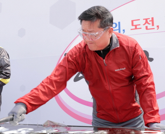 한상범 LG디스플레이 부회장이 26일 경기도 파주 사업장에서 개최된 ‘2018년 혁신목표 필달 결의대회’에서 한계를 돌파 해야 할 대상들을 55인치 폐 액정표시장치(LCD) 모듈에 붙여 망치로 깨부수는 퍼포먼스를 하고 있다.ⓒLG디스플레이