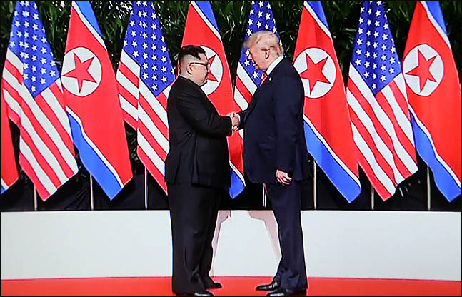 김정은 북한 국무위원장과 도널드 트럼프 미국 대통령이 12일 싱가포르 카펠라 호텔에서 북미정상회담 시작에 앞서 악수를 하고 있다 ⓒjtbc 화면촬영