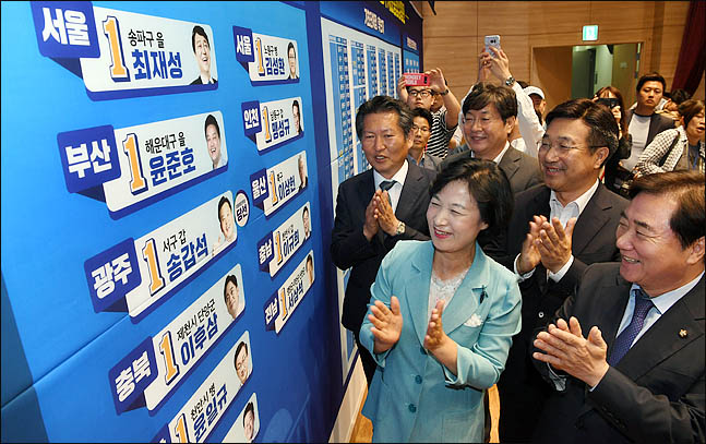 추미애 더불어민주당 대표가 13일 오후 서울 여의도 국회 의원회관에 마련된 개표상황실에서 당선이 확실시 된 후보들의 이름표 옆에 스티커를 붙인뒤 박수를 치고 있다. ⓒ데일리안