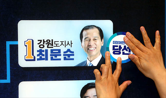 추미애 더불어민주당 대표가 13일 오후 서울 여의도 국회 의원회관에 마련된 개표상황실에서 당선이 확실해진 최문순 강원도지사 후보의 이름표에 당선 스티커를 붙이고 있다. ⓒ데일리안