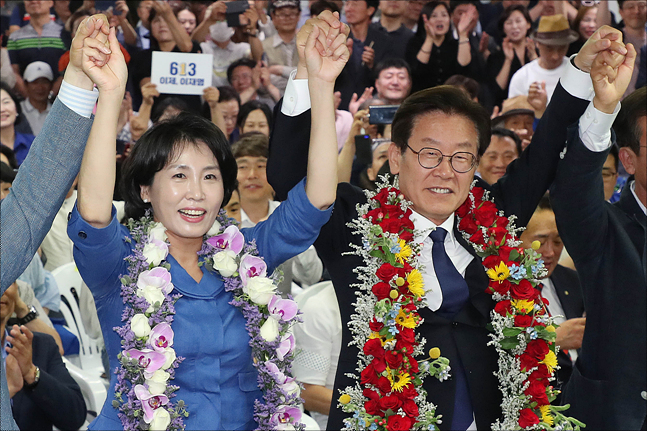 제7회 전국동시지방선거에서 경기도지사로 당선이 확정된 이재명 더불어민주당 경기도지사 후보와 부인 김혜경 씨가 13일 경기도 수원 팔달구에 위치한 명캠프 선거사무소를 찾아 꽃목걸이를 목에 건 후 손을 들올리며 기뻐하고 있다. ⓒ데일리안 홍금표 기자