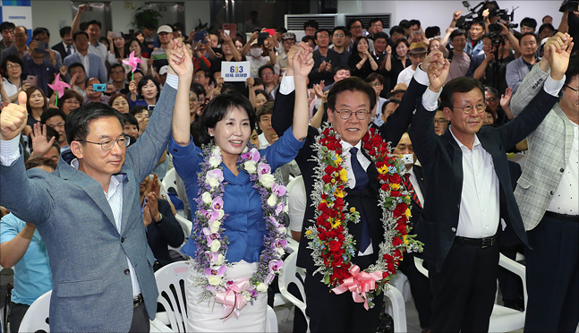 제7회 전국동시지방선거에서 경기도지사로 당선이 확정된 이재명 더불어민주당 경기도지사 후보와 부인 김혜경 씨가 13일 경기도 수원 팔달구에 위치한 명캠프 선거사무소를 찾아 꽃목걸이를 목에 건 후 손을 들올리고 있다. ⓒ데일리안 홍금표 기자