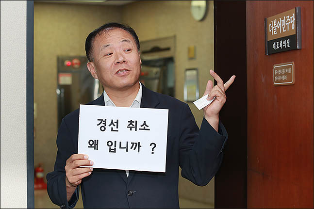 더불어민주당 지역위원장 후보가 지난 13일 지역위원장 선정 과정에서 조강특위의 경선 결정을 최고위에서 뒤집고 단수 추천한 것에 항의하며 당대표 회의실 앞에서 피케팅을 하고 있다. ⓒ데일리안 류영주 기자