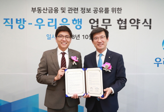 안성우(왼쪽) 직방 대표이사와 이창재 우리은행 부동산금융그룹 부행장이 12일 서울 중구 우리은행 본점에서 부동산 신사업 개발을 위한 포괄적 업무협약을 체결한 뒤 기념촬영을 하고 있다.ⓒ우리은행