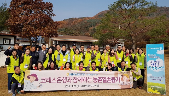 6일 경기도 가평 아홉마지기 마을에서 진행된 농촌일손돕기에 참가한 NH농협은행, 코레스은행 임직원들이 기념촬영을 하고 있다.ⓒNH농협은행